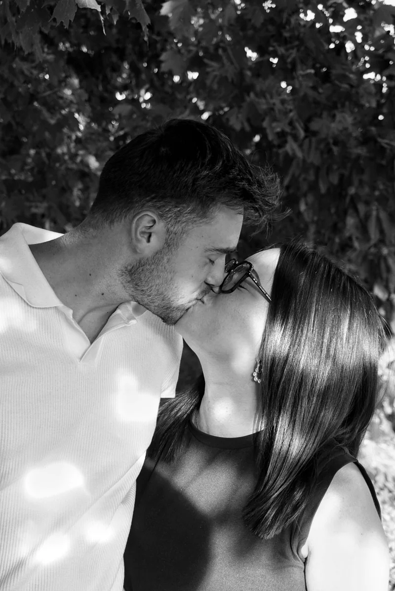 Un couple s’embrasse en extérieur, en noir et blanc