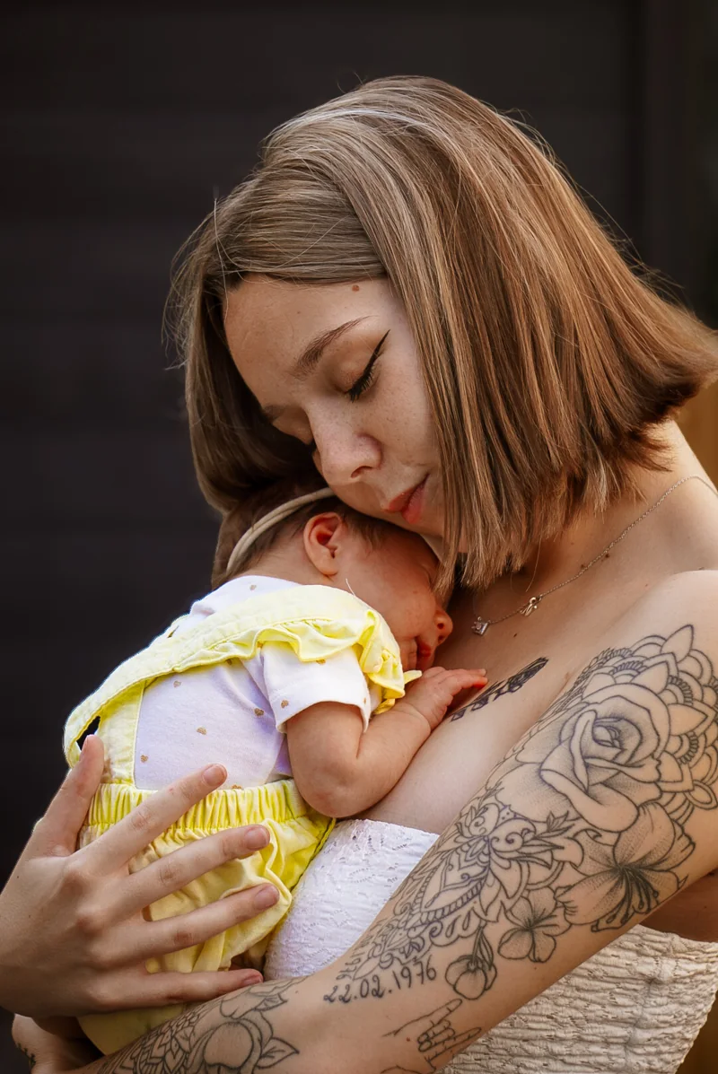 Une maman embrasse son nouveau-né qu’elle tient contre elle