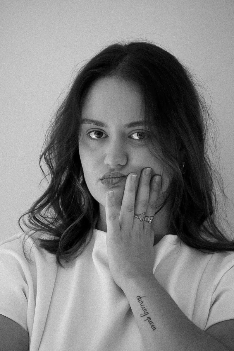 Portrait en noir et blanc d’une femme, une main devant la bouche